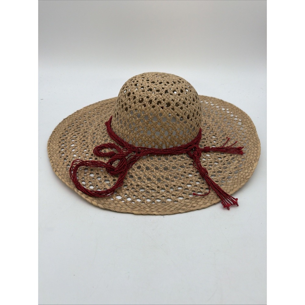 tan woven straw sun hat with a wide brim and a decorative red